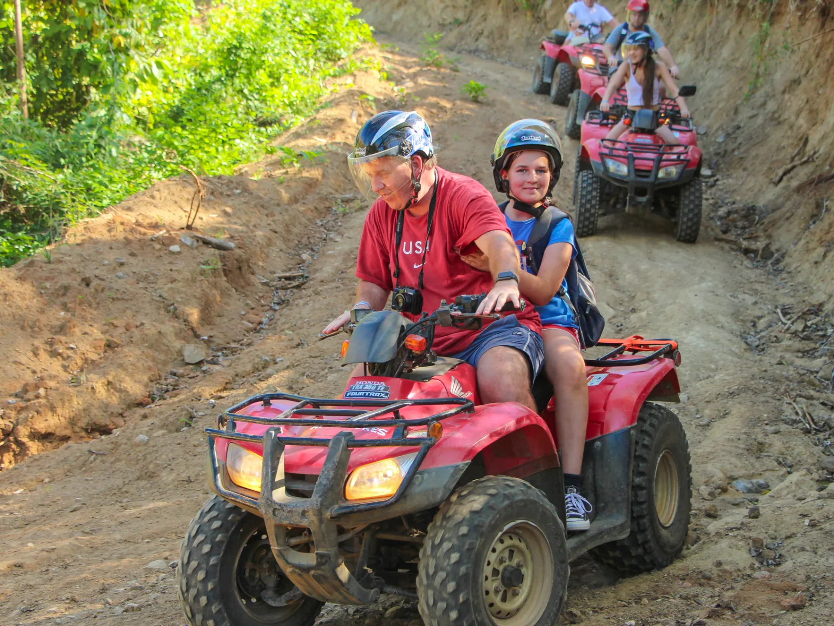 People riding ATVs through the forest
