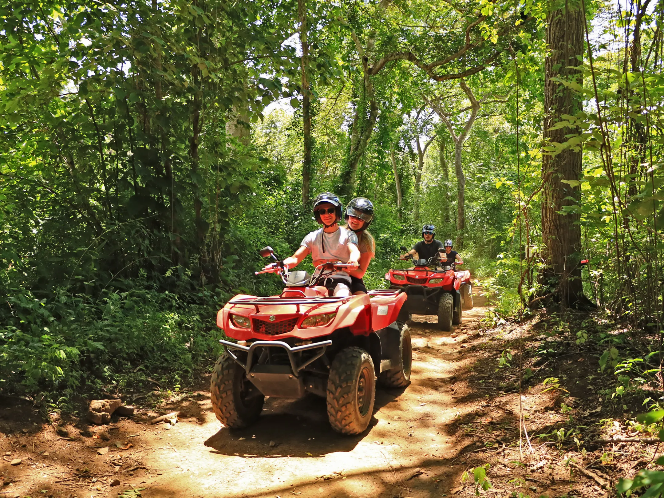 A group riding ATVs through the jungle