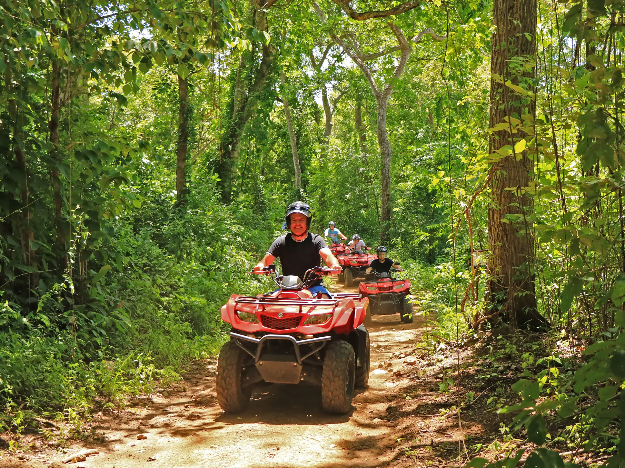 A group riding ATVs through the jungle