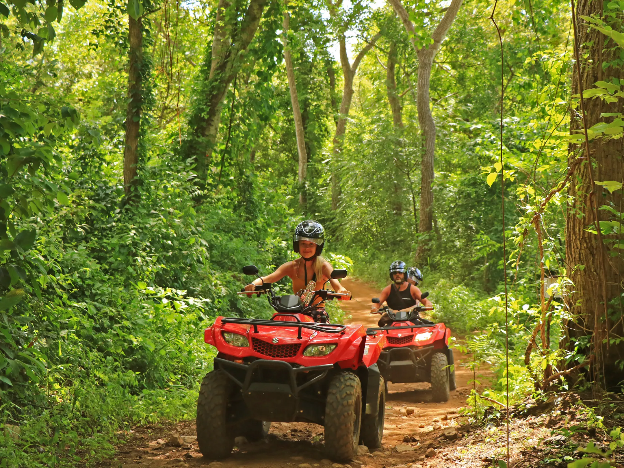 A group riding ATVs through the jungle