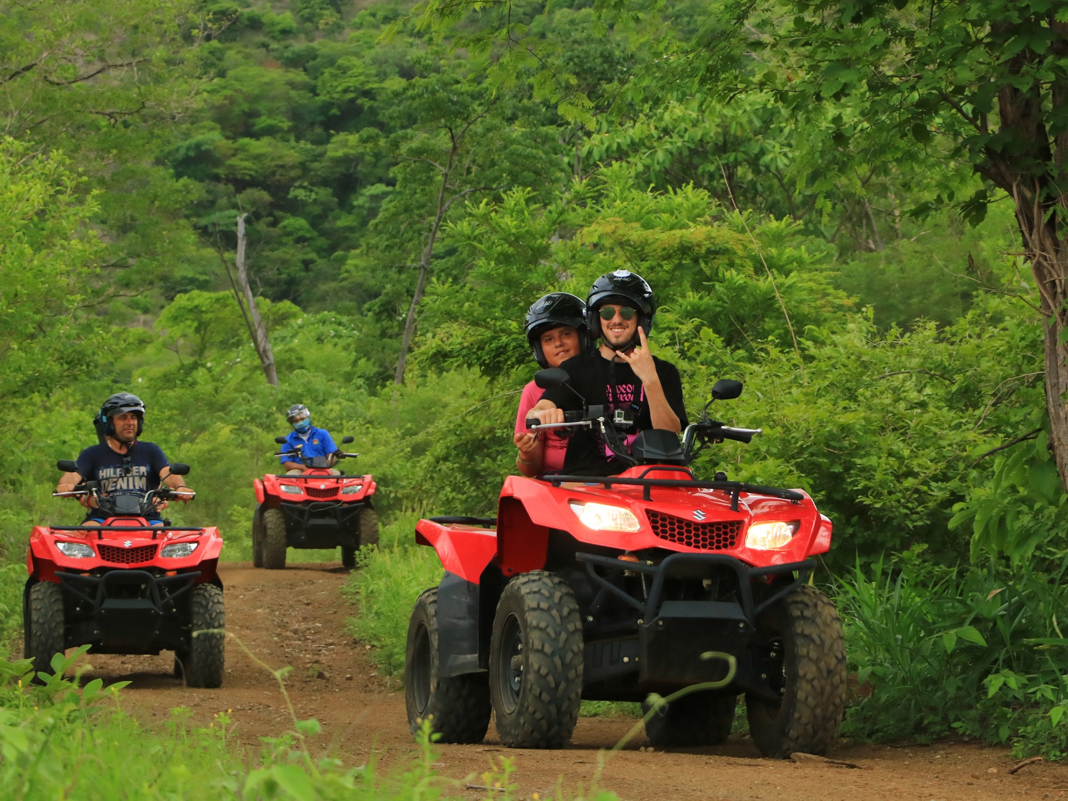 A group riding ATVs through the jungle