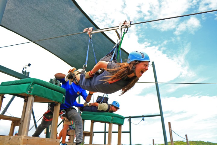 A woman screaming as she beings to zipline