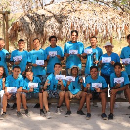 a group of people sitting on a bench posing for the camera