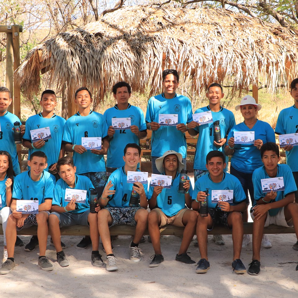 a group of people sitting on a bench posing for the camera