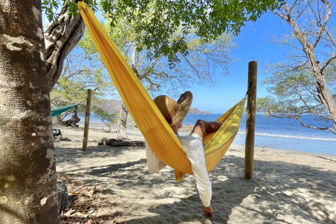 Person in a hammock in front of the ocean