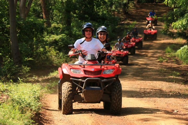 a man riding a motorcycle down a dirt road