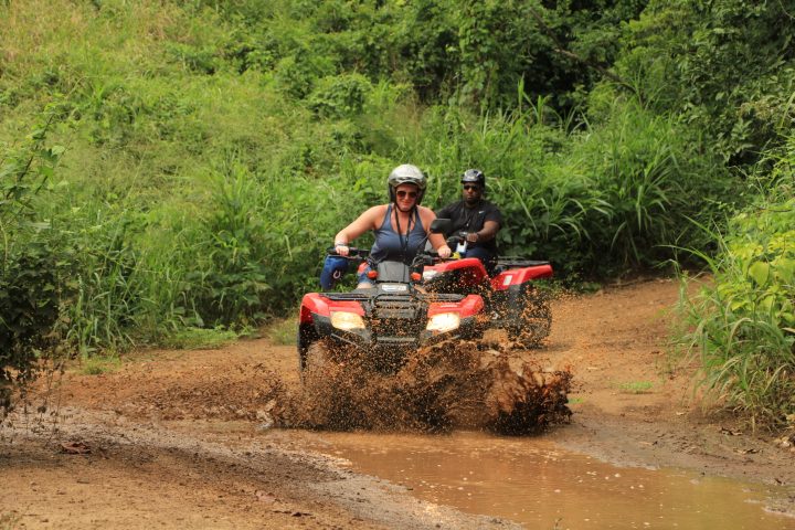 a man riding a motorcycle down a dirt road