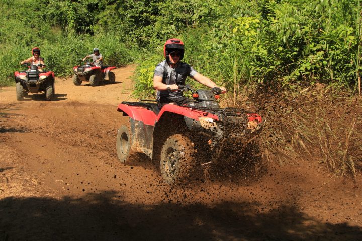 a man riding a motorcycle down a dirt road