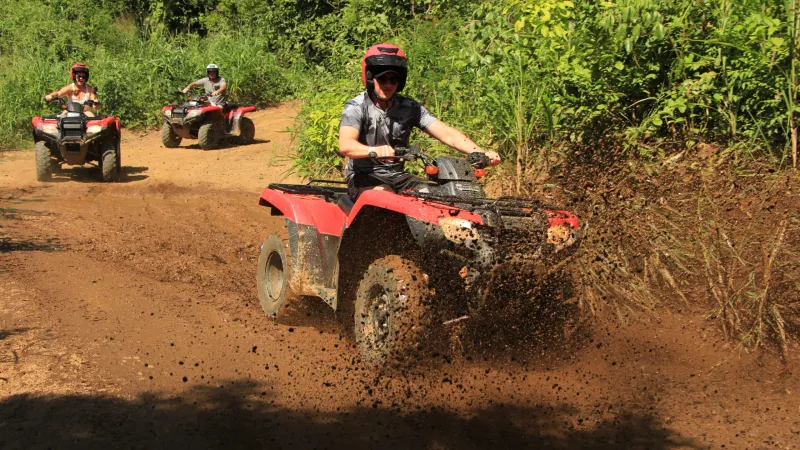 a man riding a motorcycle down a dirt road