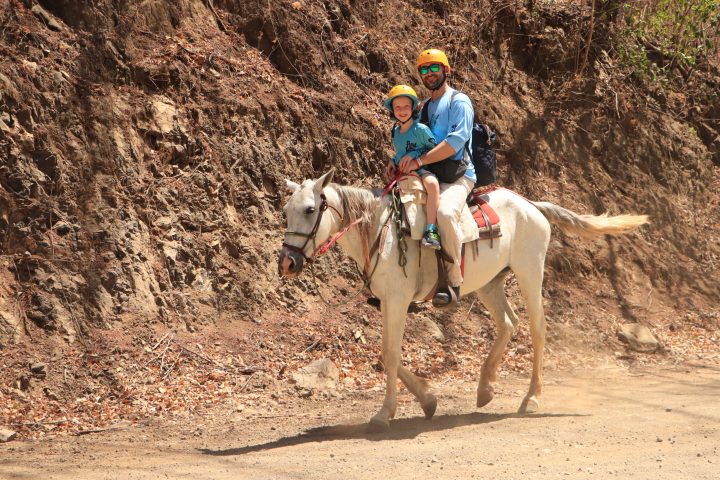 a man riding a horse on a dirt path