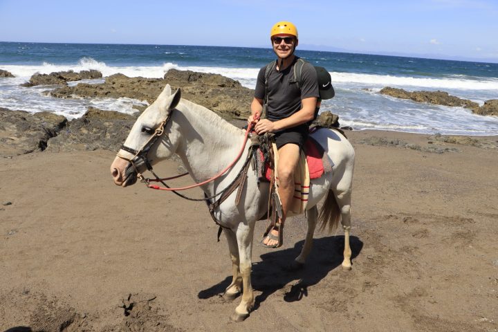 a man riding a horse on a beach