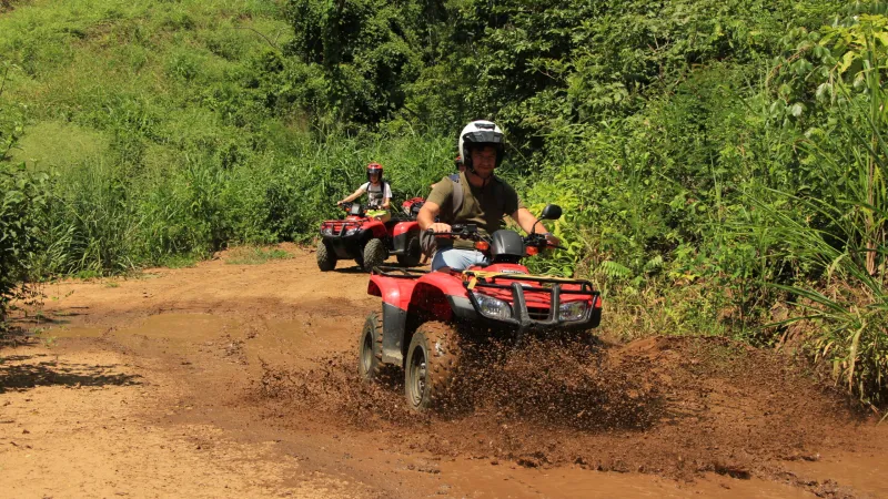a man riding a motorcycle down a dirt road