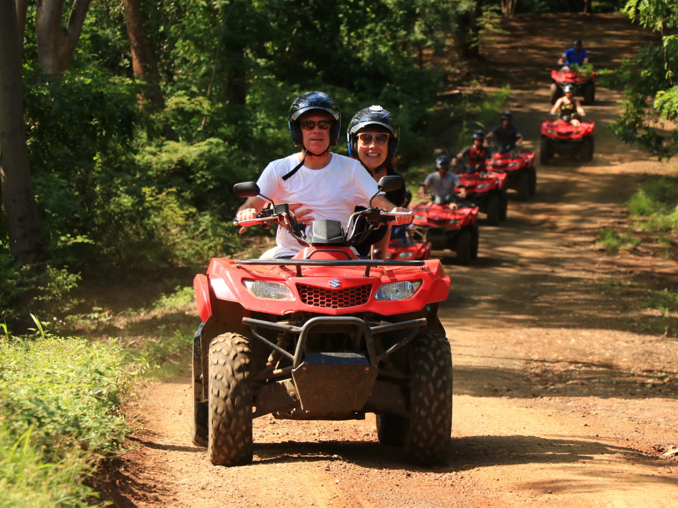 a man riding a motorcycle down a dirt road