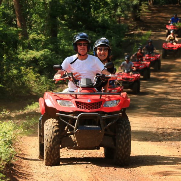 a man riding a motorcycle down a dirt road