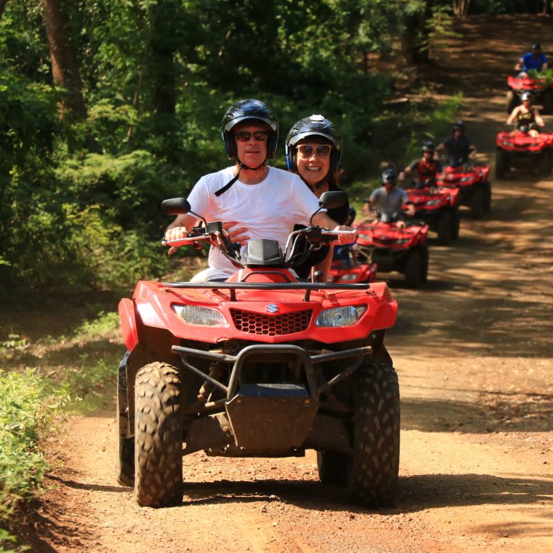 a man riding a motorcycle down a dirt road