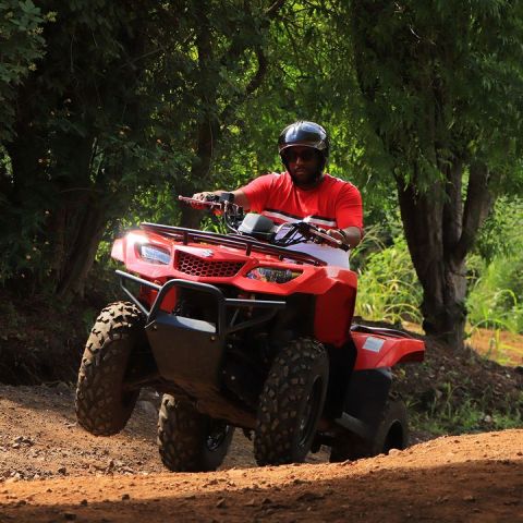 a man riding a motorcycle down a dirt road