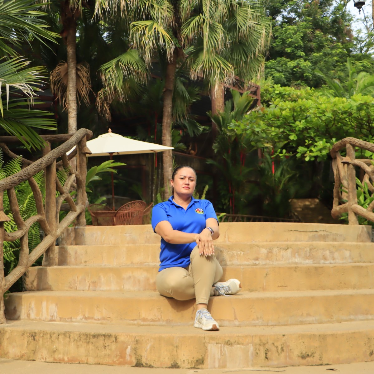 a person sitting on a bench next to a palm tree