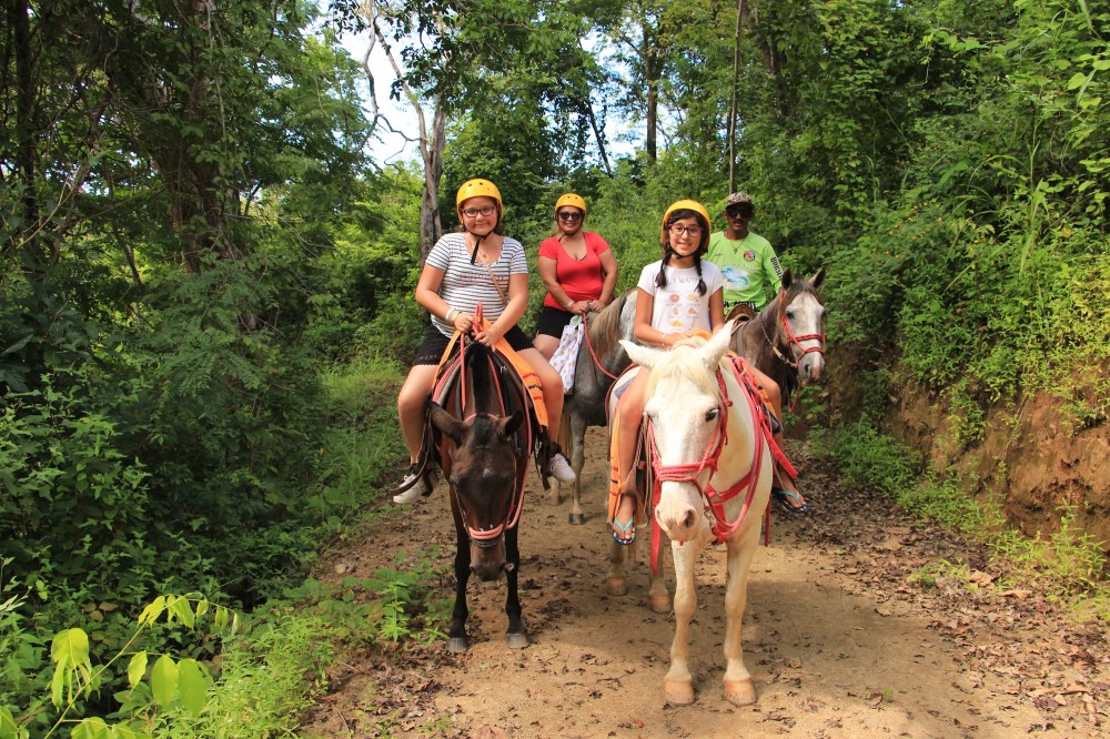 Riders wearing helmets on a guided horseback tour at Diamante in Costa Rica