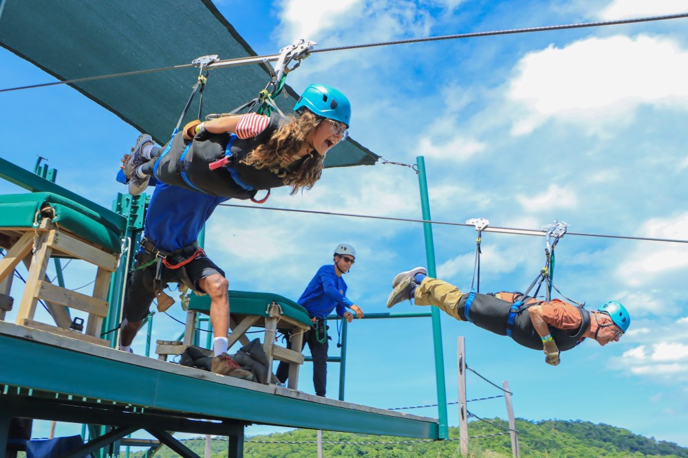 Guides preparing a guest for the Superman zip line launch at Diamante