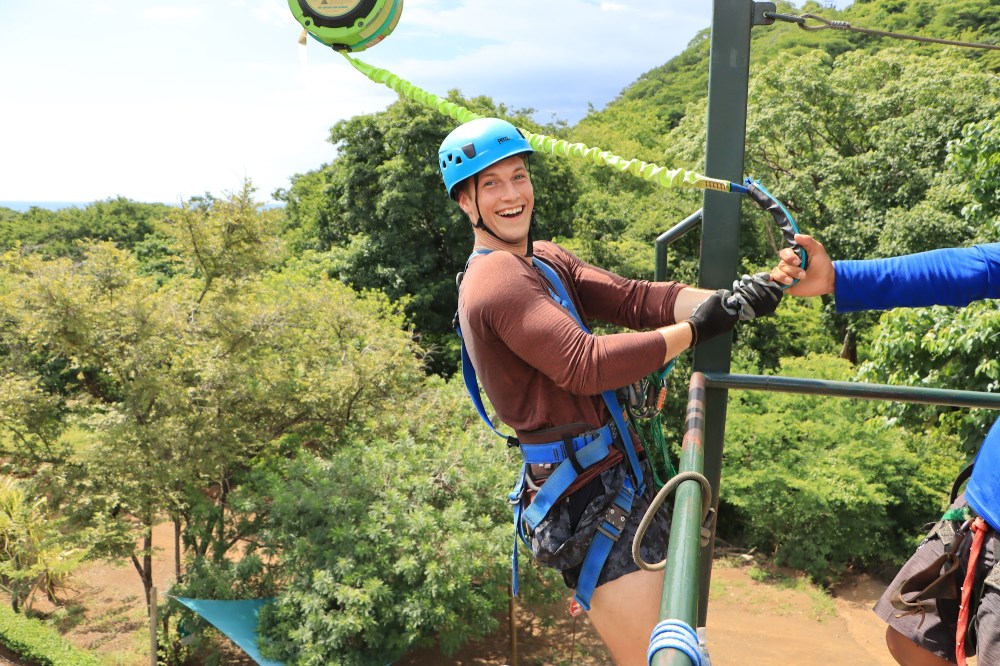 Diamante zip line guide on the platform with harness and safety equipment